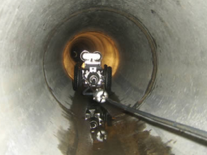 Un robot rampe dans un tuyau d'évacuation.