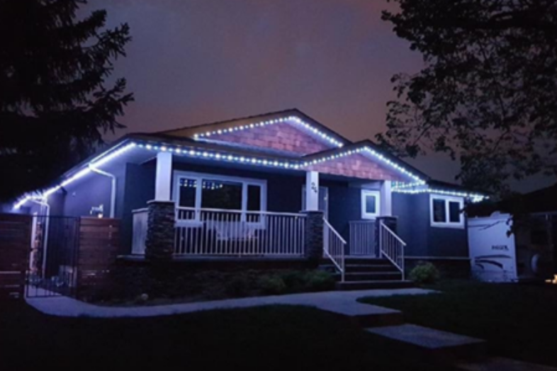 A house with permanent christmas lights on it at night