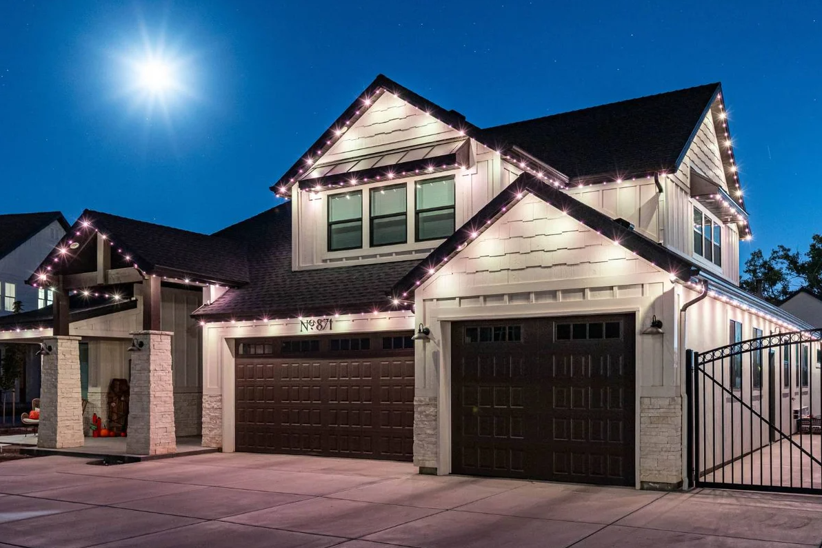Trimlight outdoor security lights highlighting driveway, entryways, and surrounding areas of a home