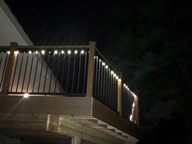 A deck with lights on it is lit up at night with permanent bulbs