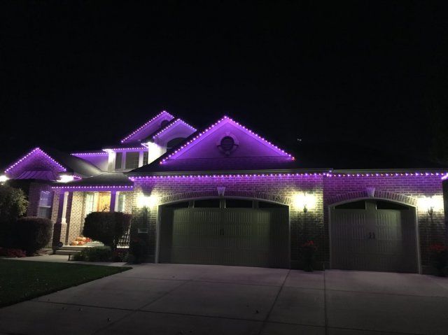 A house is lit up with purple permanent lights at night