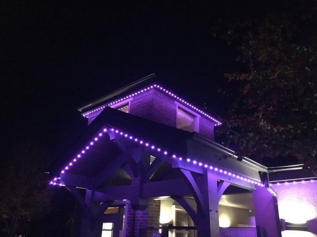 A building with purple permanent lights on it at night installed by rocky mountain trimlight