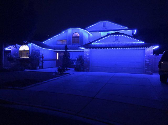 A house is lit up with blue permanent lights at night