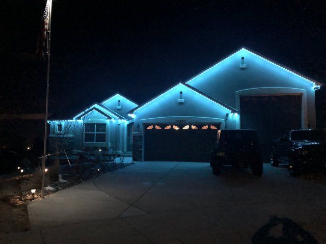 A house is lit up with blue permanent lights at night.
