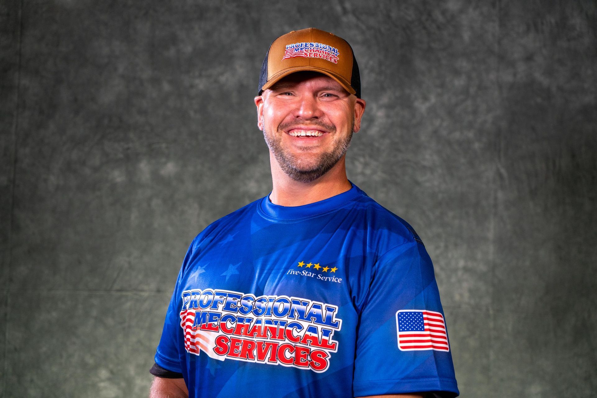 A man wearing a gray shirt and a red hat is smiling