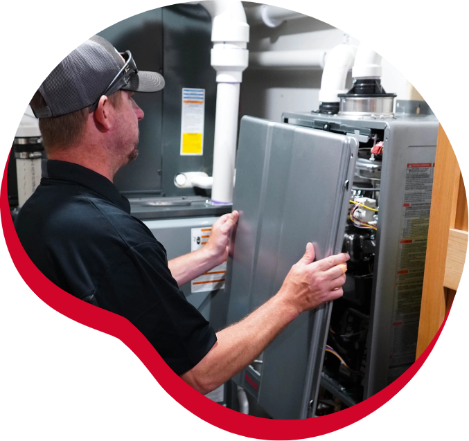 A man is working on an air conditioner in a basement