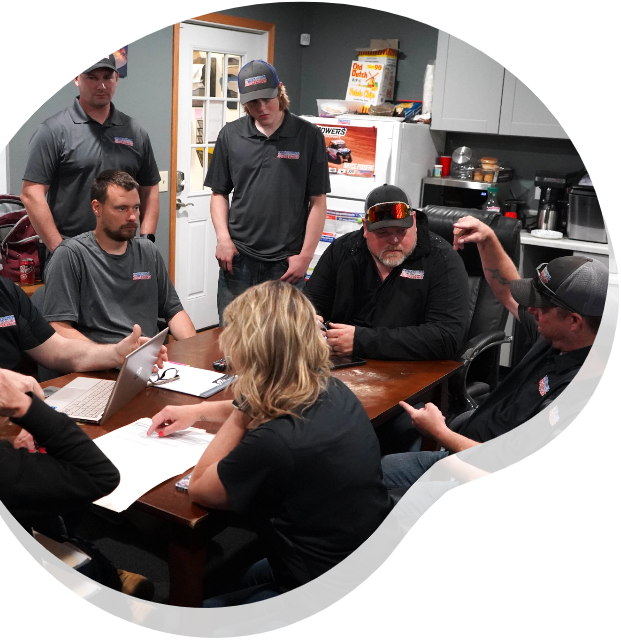 A group of people are sitting around a table with papers on it