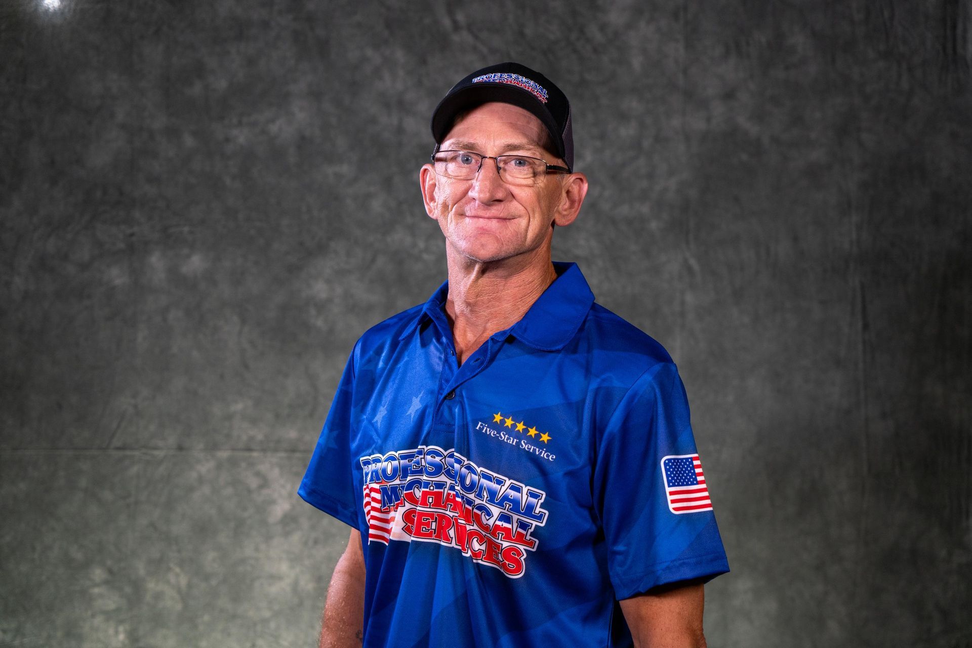 A man wearing glasses and a hat is wearing a shirt that says racing authority
