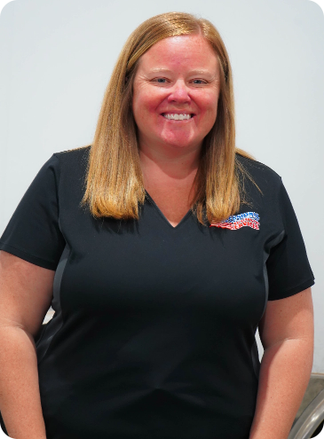 A woman in a black shirt is smiling for the camera.