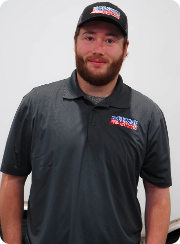 A man with a beard is wearing a polo shirt and a hat.