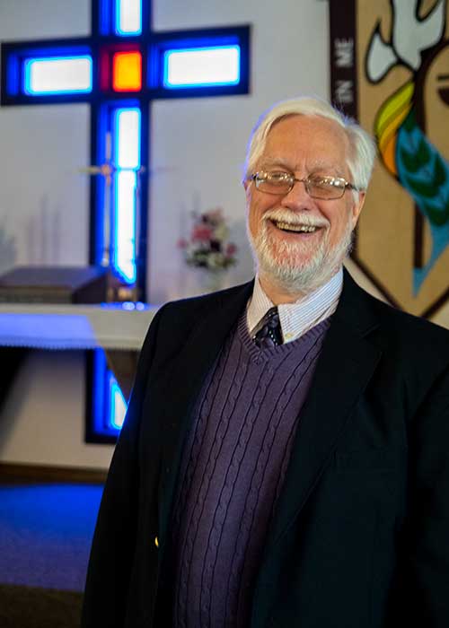 Pastor Ragner with the altar area in the background Photo of Pastor Ragner in the church.