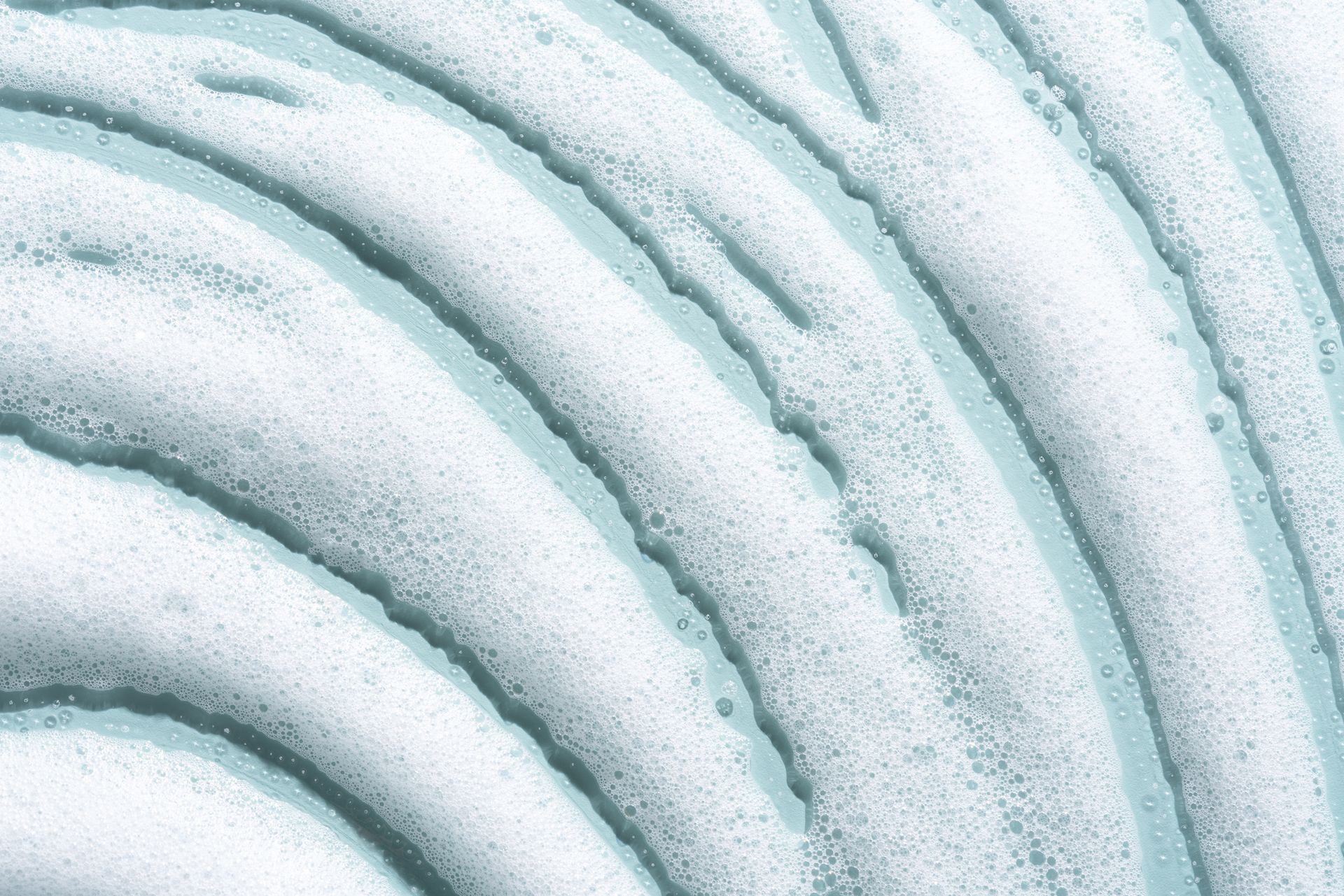 A Close-Up of A Swirl of Foam on A Blue Surface.