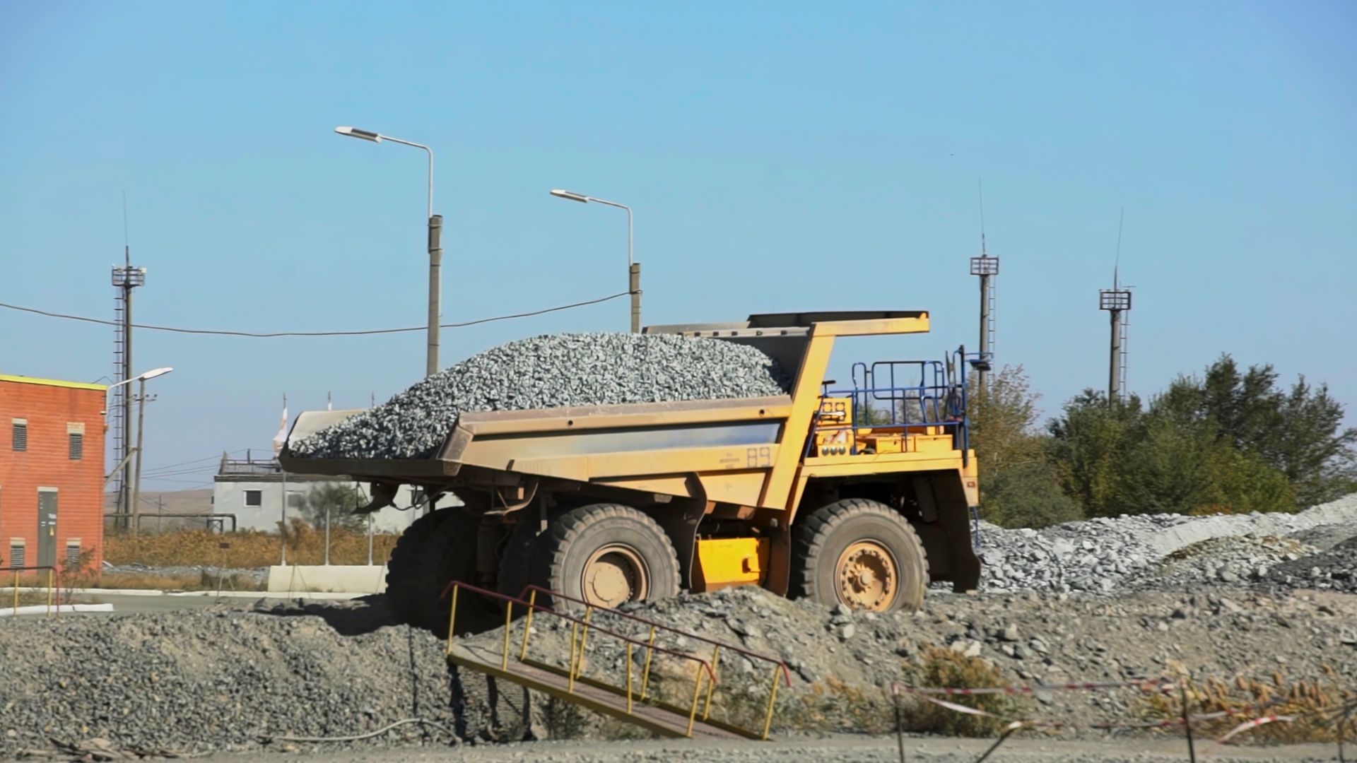 A bulldozer is scooping up a tree stump in the woods.