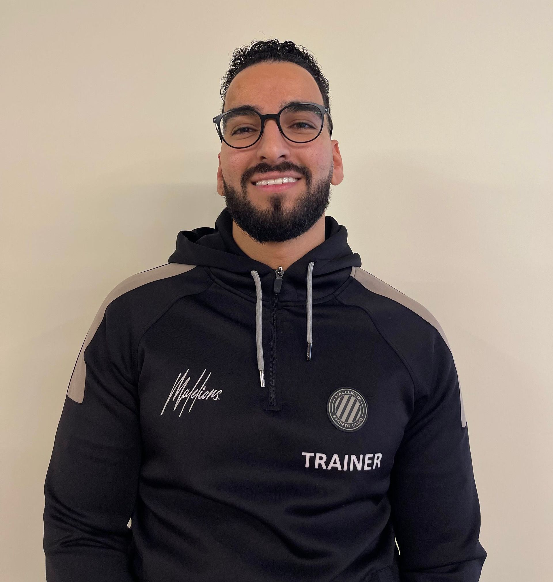 Een man met een baard draagt ​​een zwart sportsweatshirt