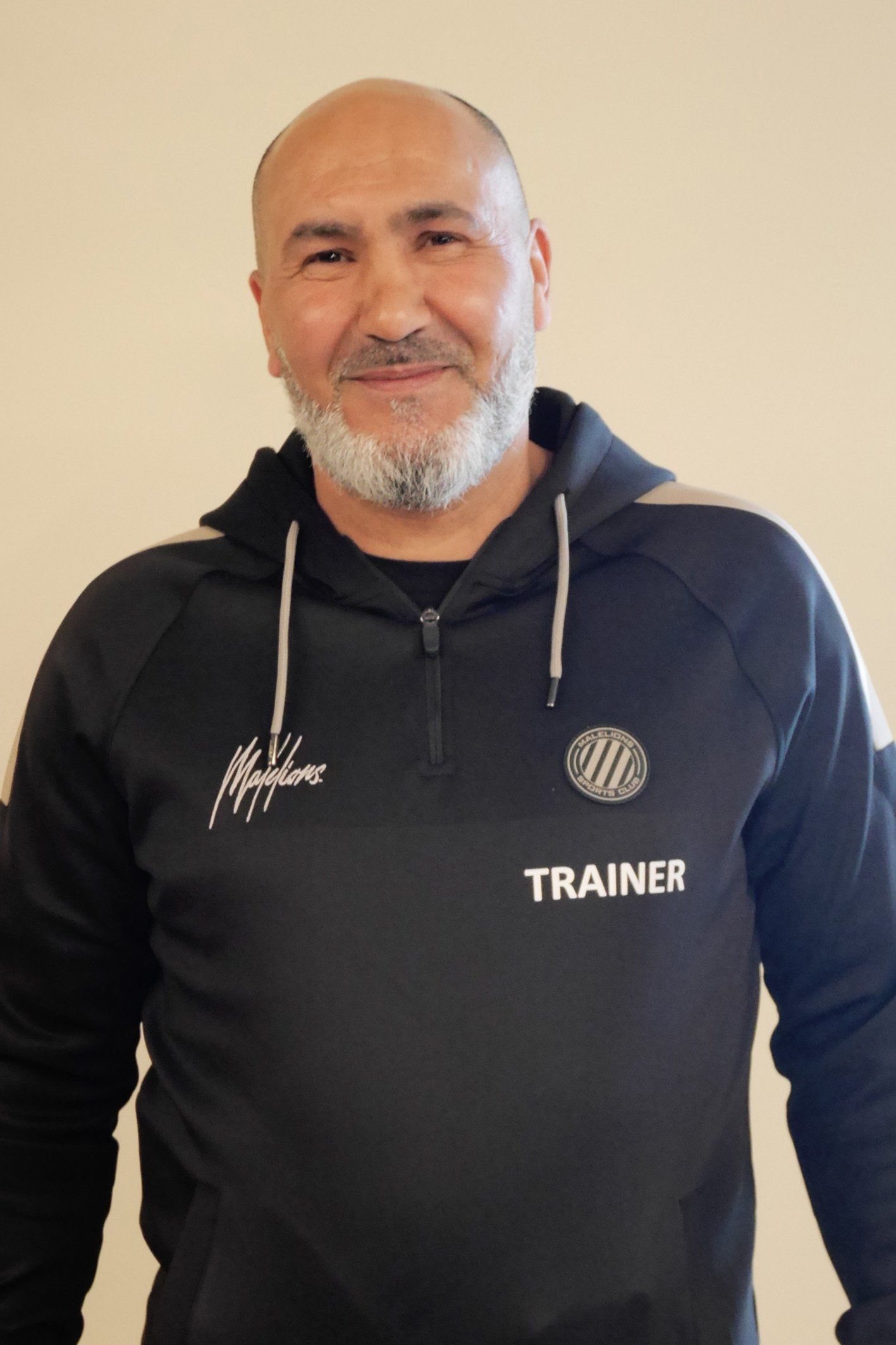 Een man met een baard draagt ​​een zwart sportsweatshirt