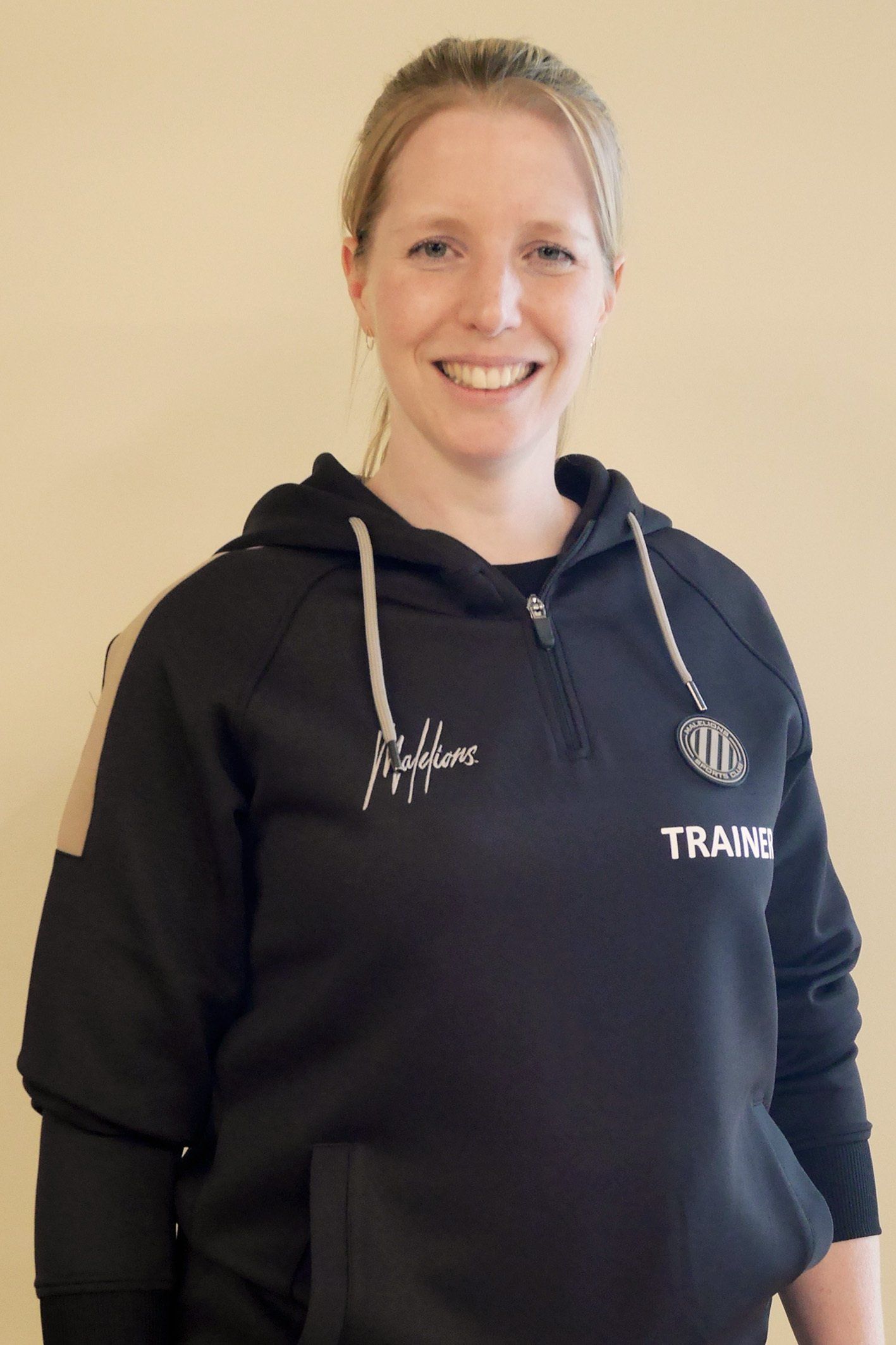 Een vrouw draagt ​​een zwarte hoodie met de tekst 'trung' erop