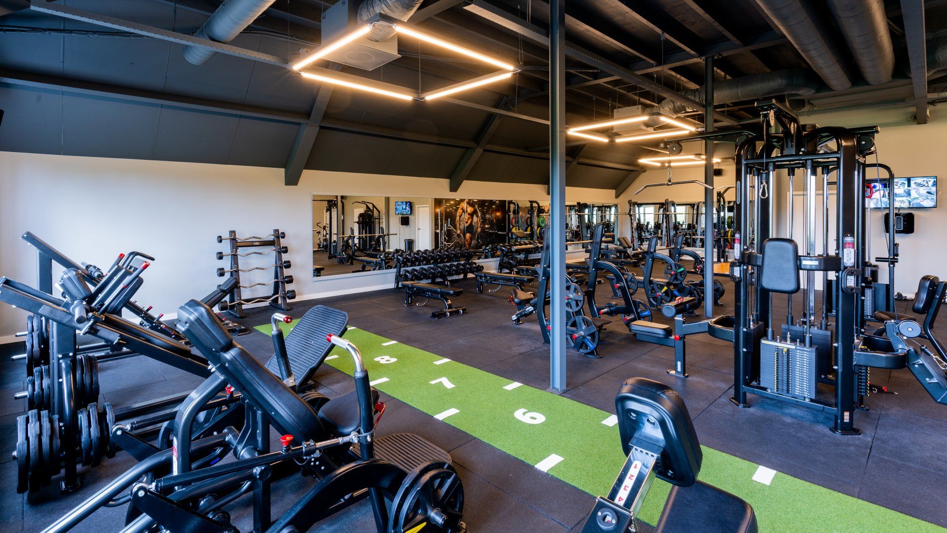 Een grote fitnessruimte vol met veel fitnessapparatuur.