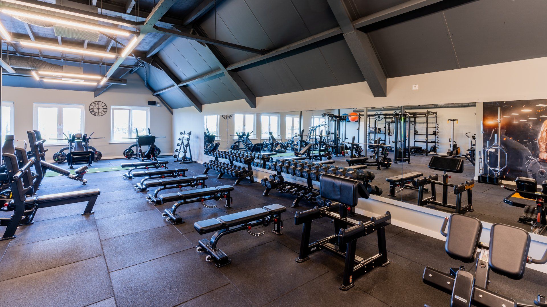 Een grote fitnessruimte vol met veel fitnessapparatuur.