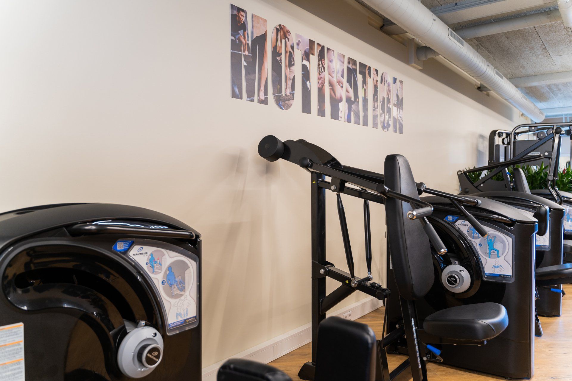 Interieur van een sportschool met fitnessapparaten tegen een muur met het woord