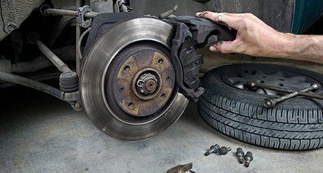 Mechanics hand on Brake disc, clutch repair, tyre, spanner