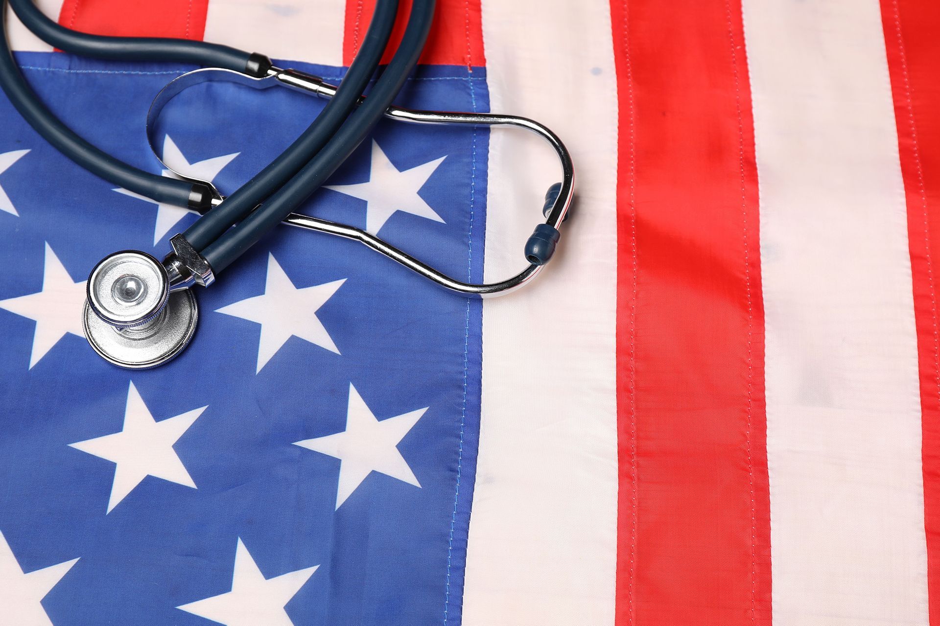 A stethoscope is laying on top of an american flag