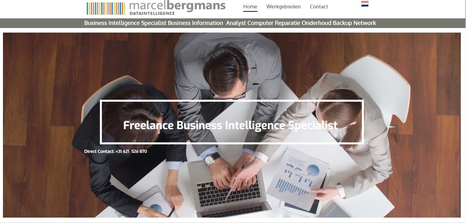 Een groep mensen zit rond een tafel met laptops.