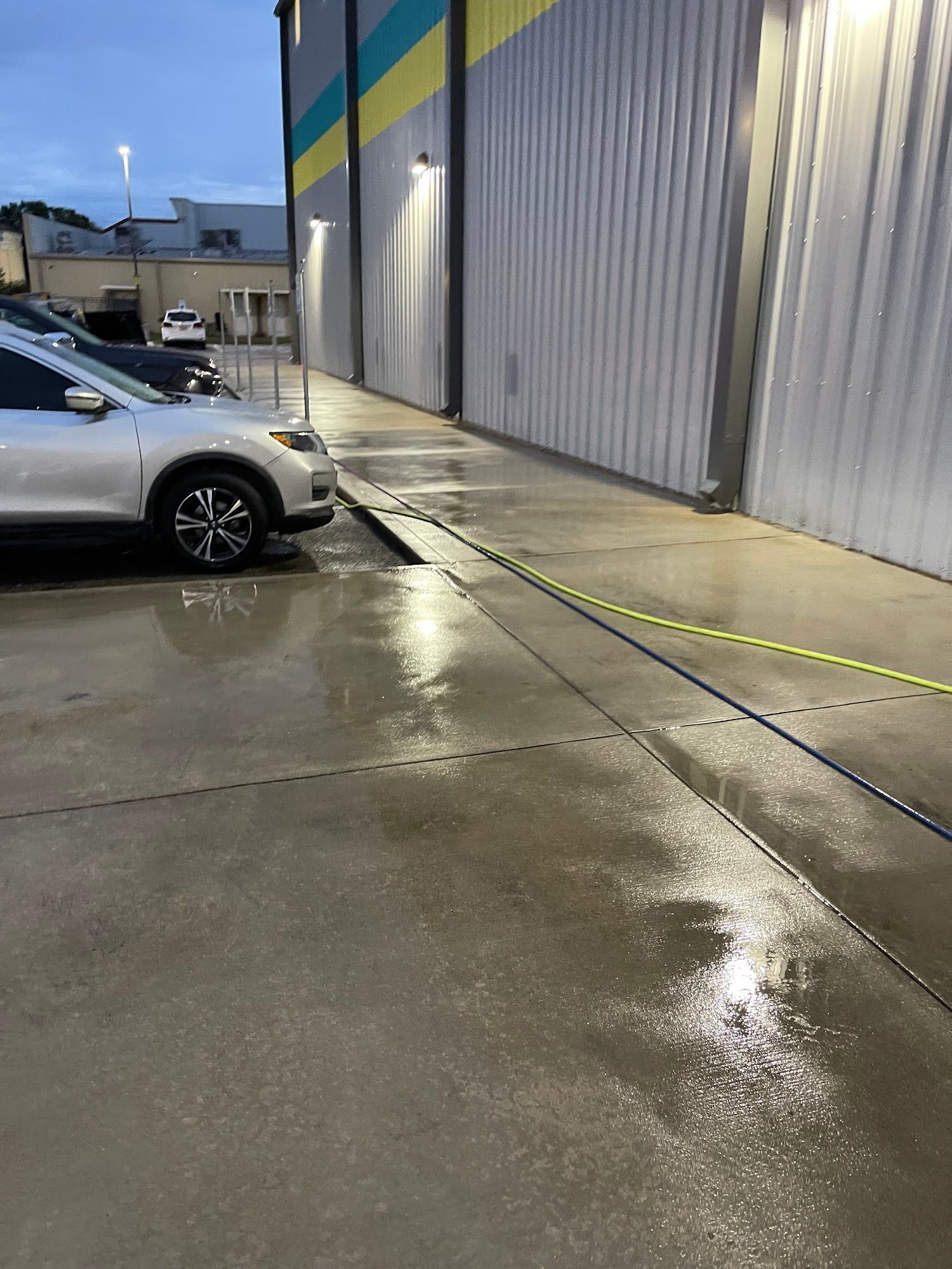 A car is parked in a parking lot next to a building.