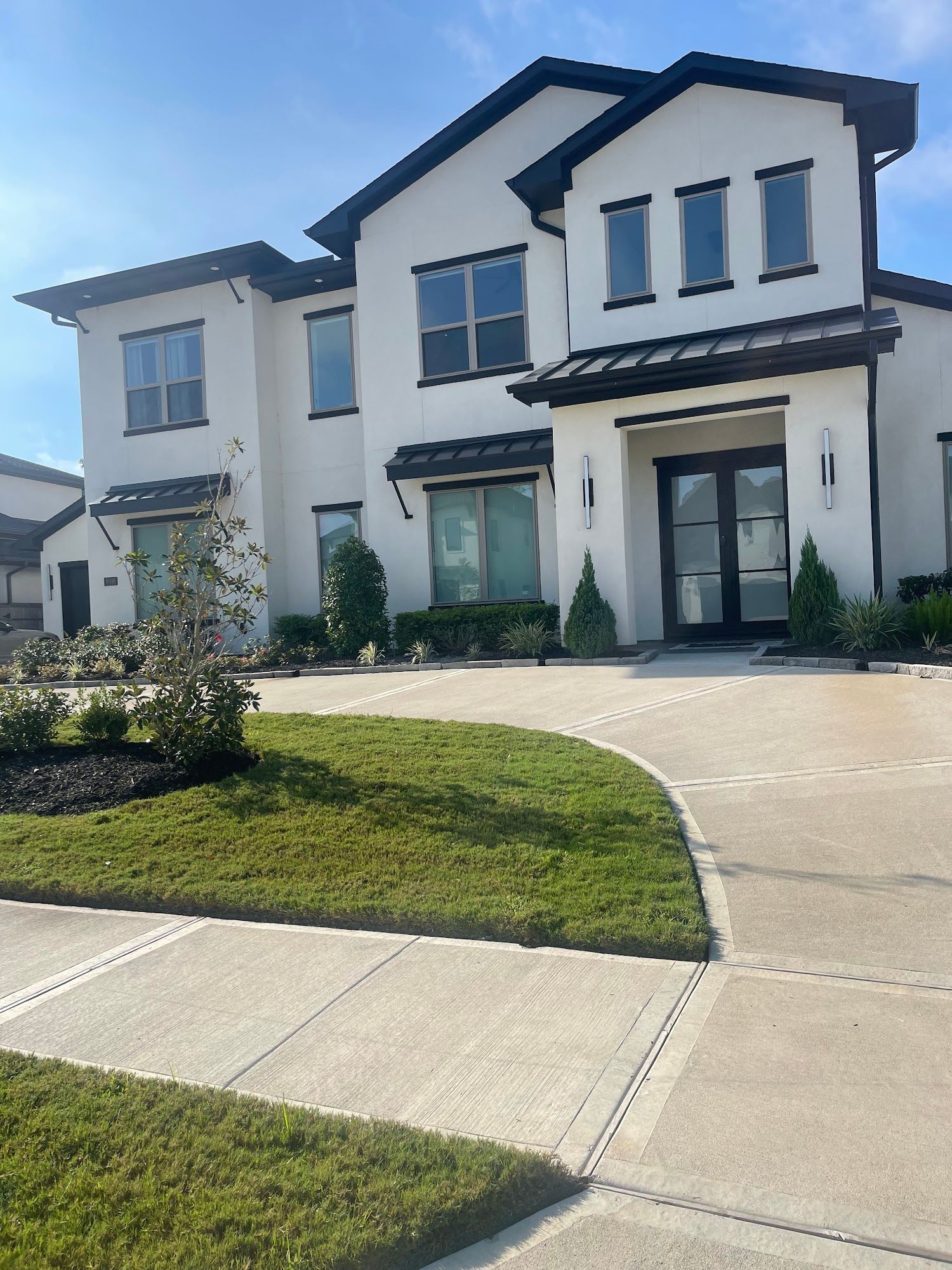 A large white house with a lot of windows and a driveway