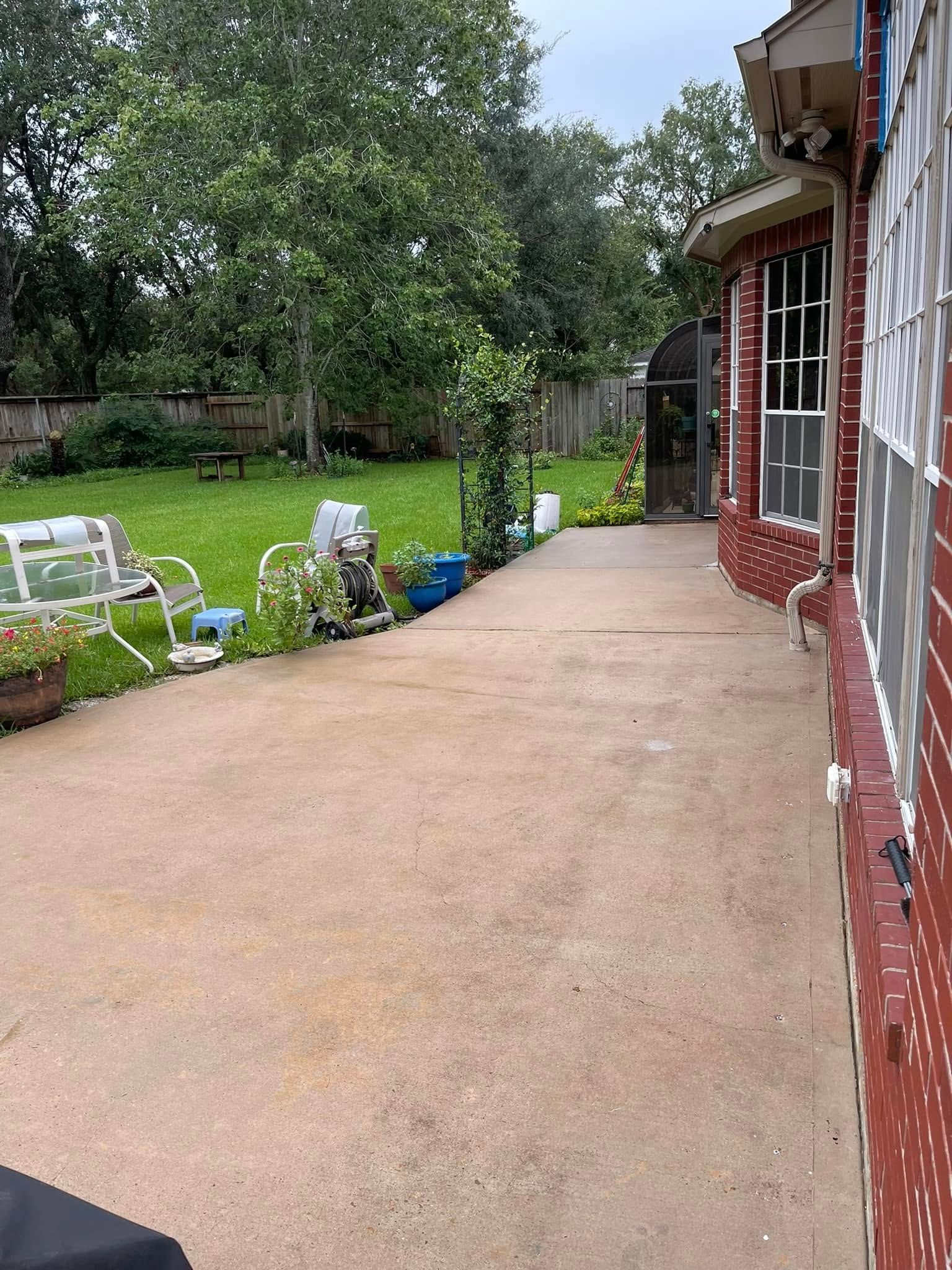 A brick house with a driveway leading to a grassy yard.