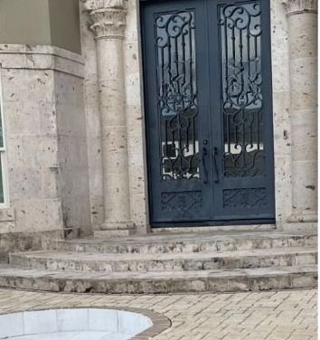 The front door of a building with stairs leading up to it.