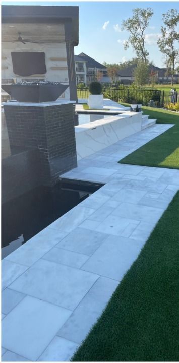 A walkway leading to a pool with a house in the background
