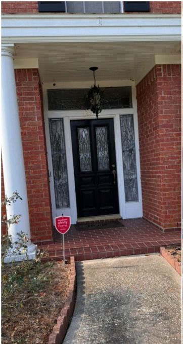 The front door of a brick house with a black door