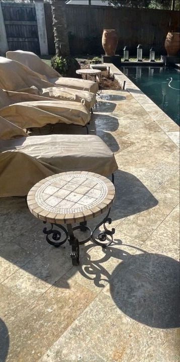 A row of lounge chairs sitting next to a swimming pool.