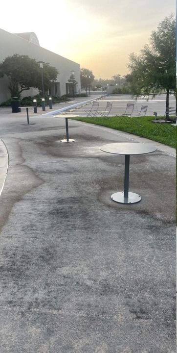 A row of tables on a sidewalk in a park.