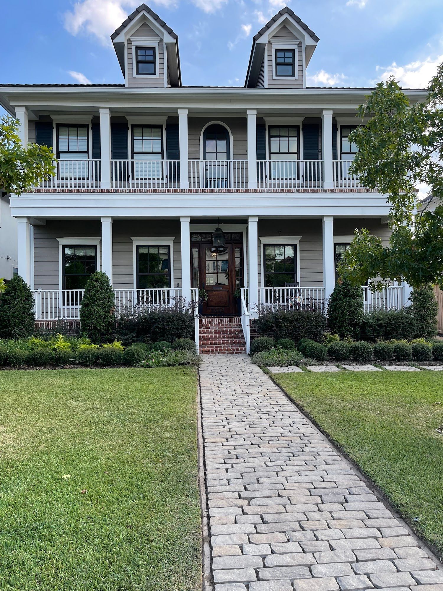 A large house with a brick walkway leading to it.