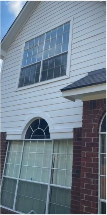 A house with a lot of windows and a brick wall.