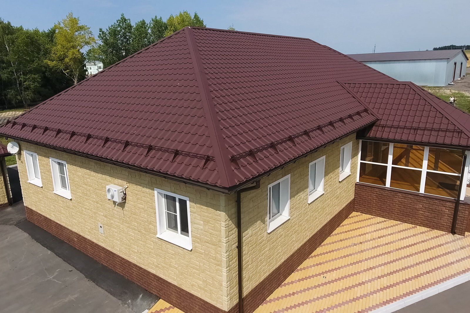 A person is cleaning the roof of a house with a pressure washer.