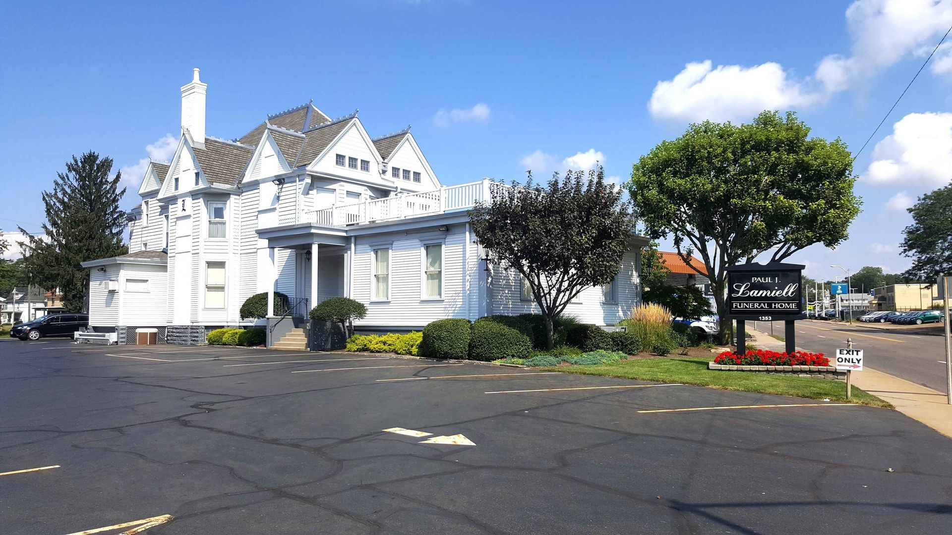 A large white building with a brown roof and a lot of windows.