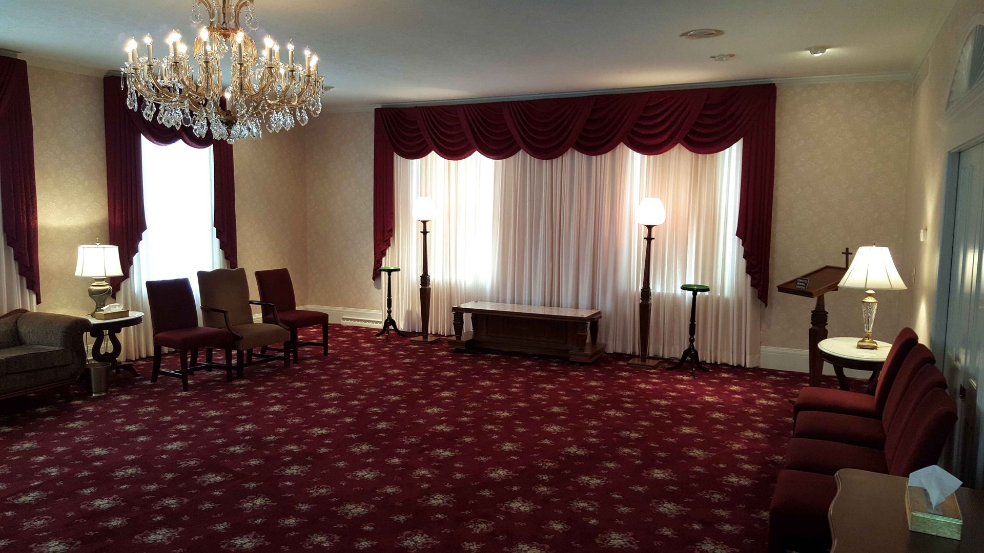 A large room with a red carpet and a chandelier.