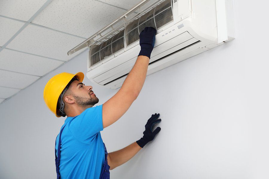 worker pulling the air conditioner filter
