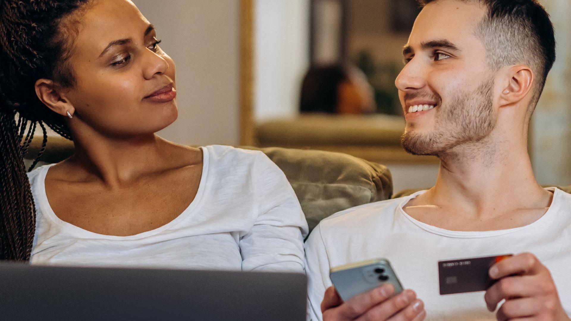 Couple paying holding credit card and laptop
