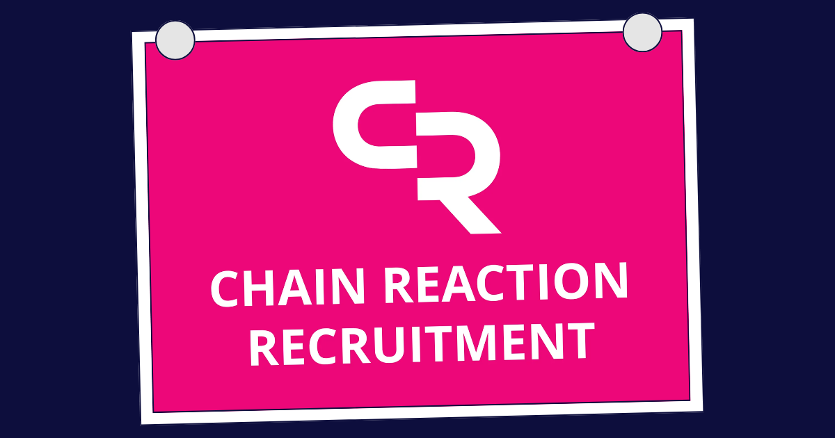 Four people collaborating at a table, looking at papers with charts and graphs, in a modern office.