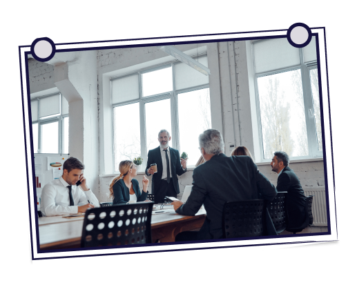 Woman waving at computer while man smiles, leaning in. Yellow computer, home setting.