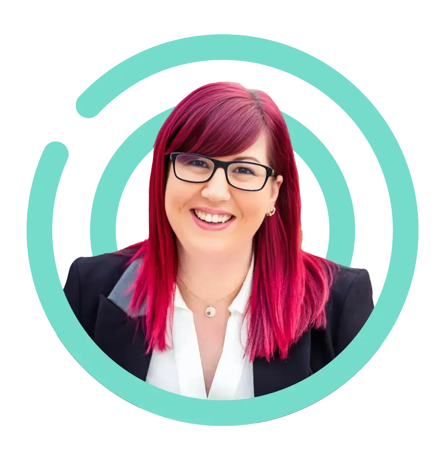 Woman with red hair and glasses smiling in a blazer, turquoise circle design behind her.