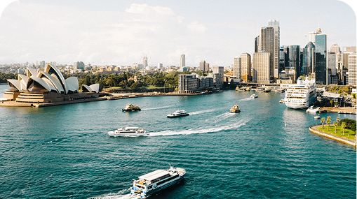 Sydney Harbour with the Opera House, boats, and city skyline.