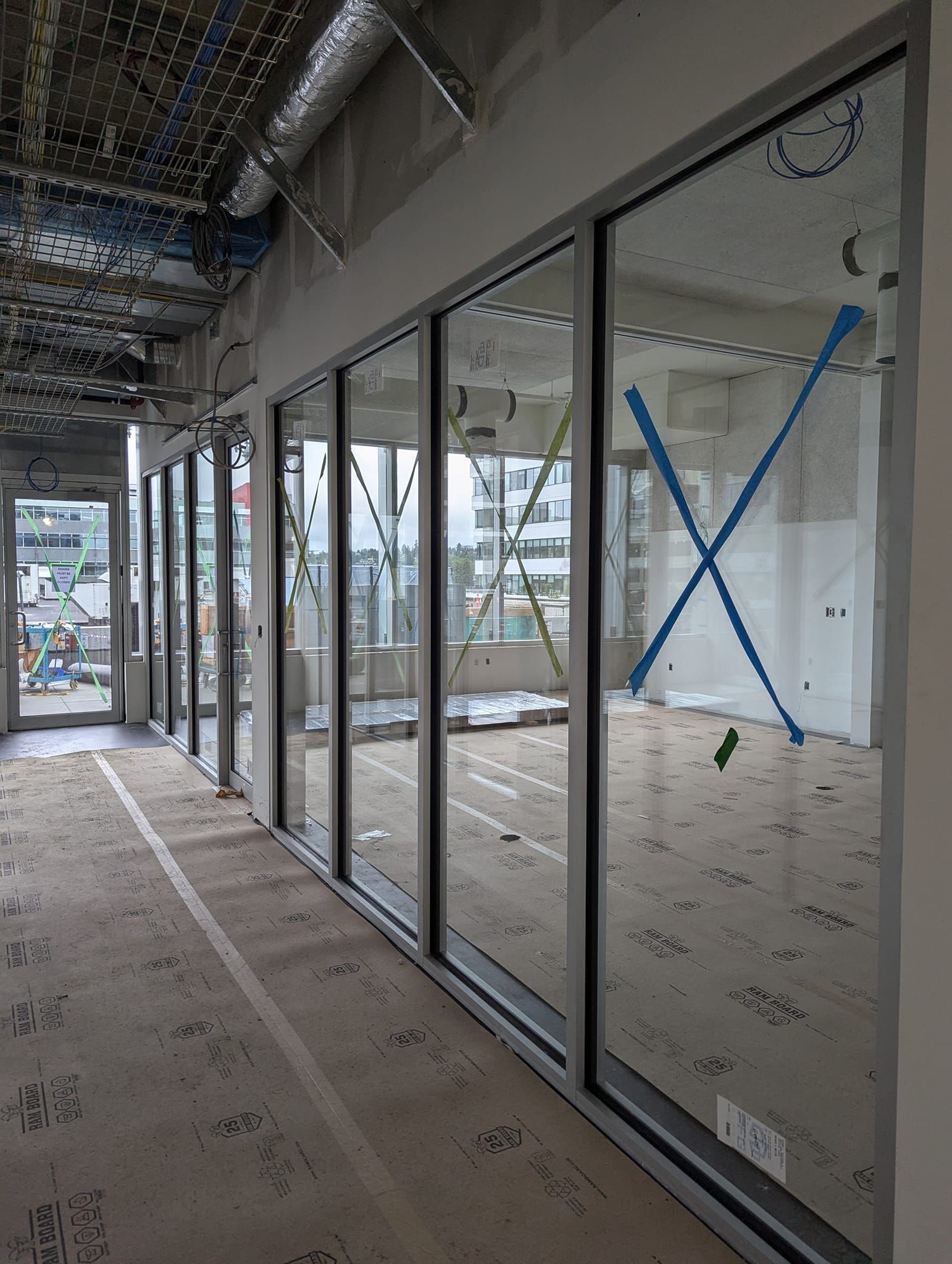 A building under construction with a lot of windows and a blue x on the wall.