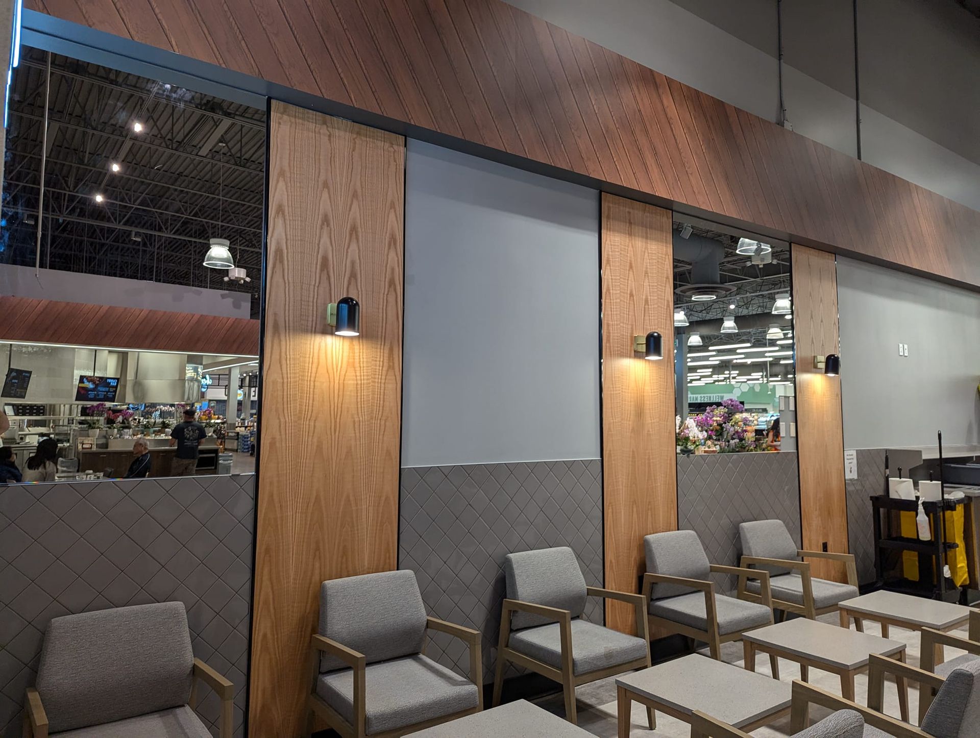 A waiting area in a restaurant with chairs and tables.