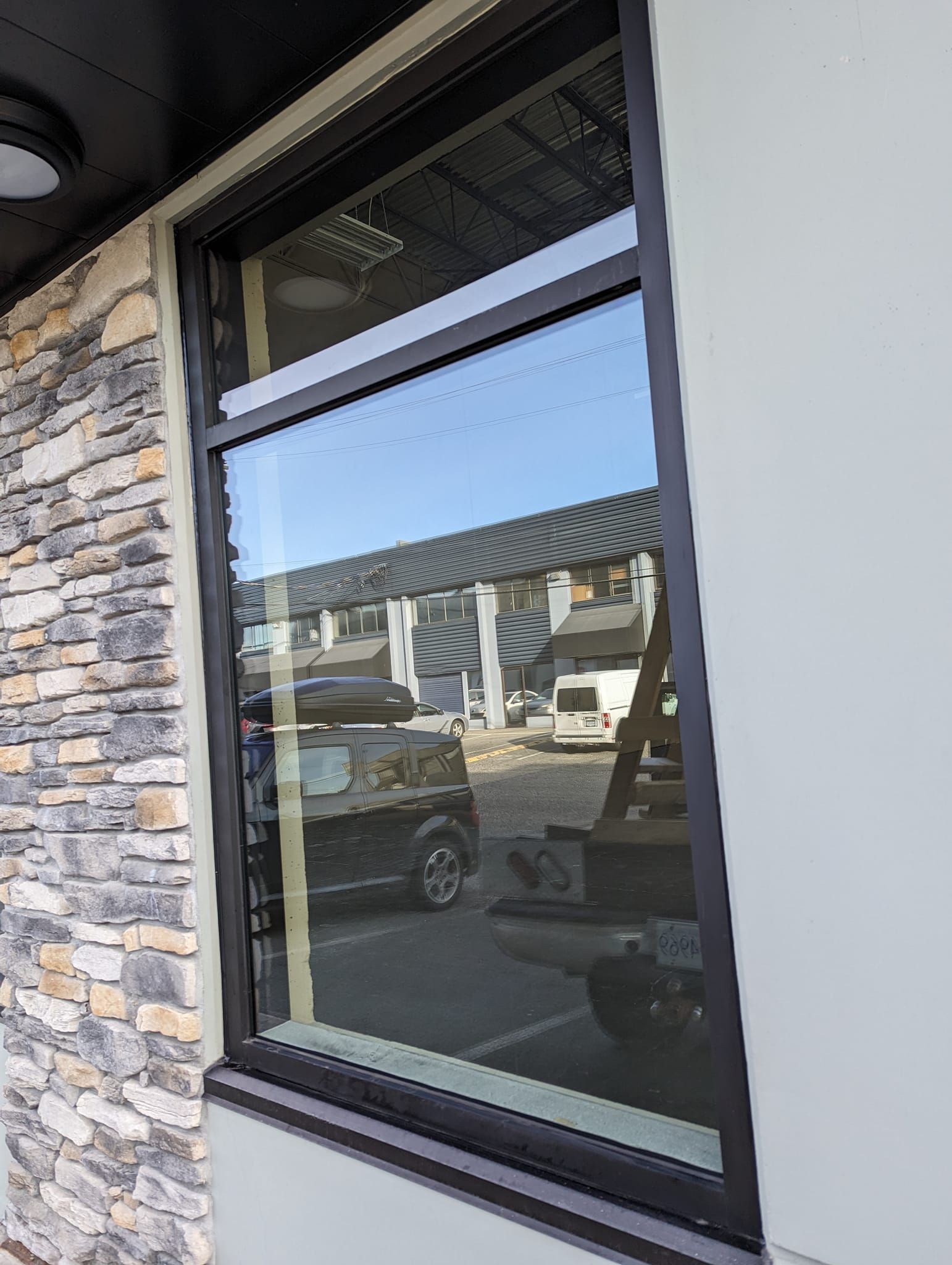 A window on the side of a building with a car parked in front of it.