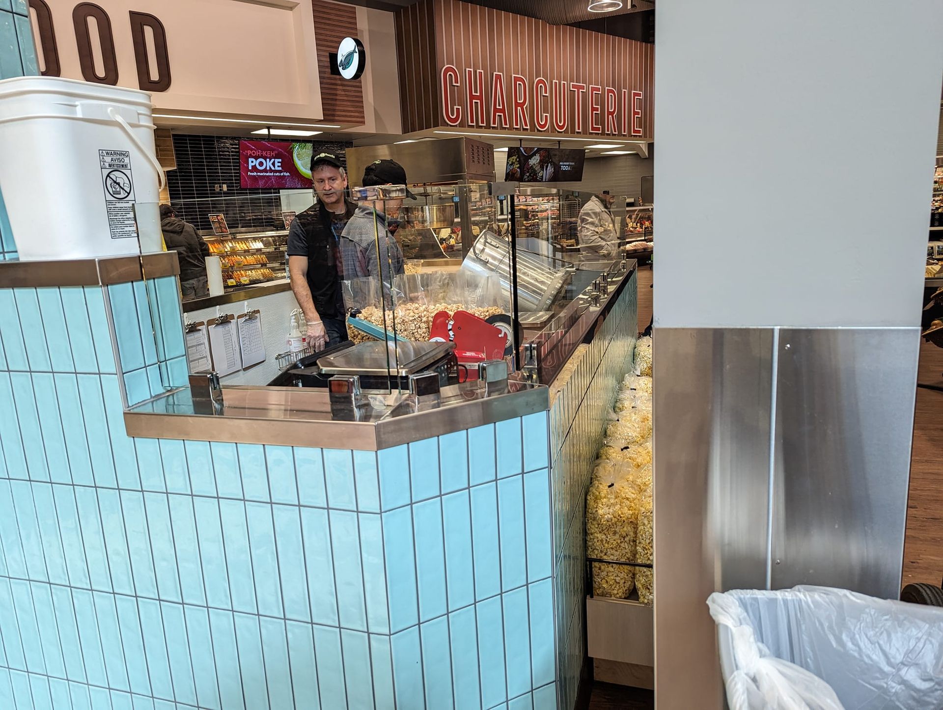 A man is standing behind a counter in a restaurant.