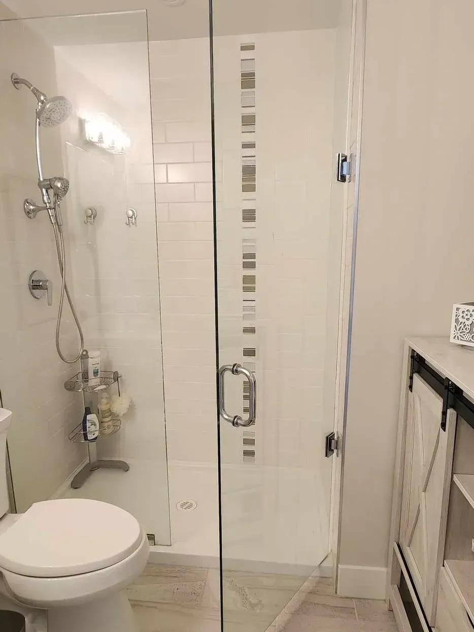 A bathroom with a toilet , shower , and sink.